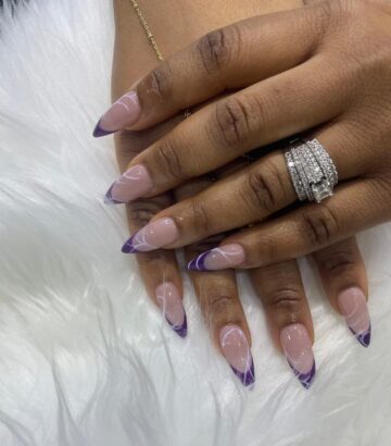 Acrylic nails with purple French tips at a luxury nail salon in Ikoyi Lagos
